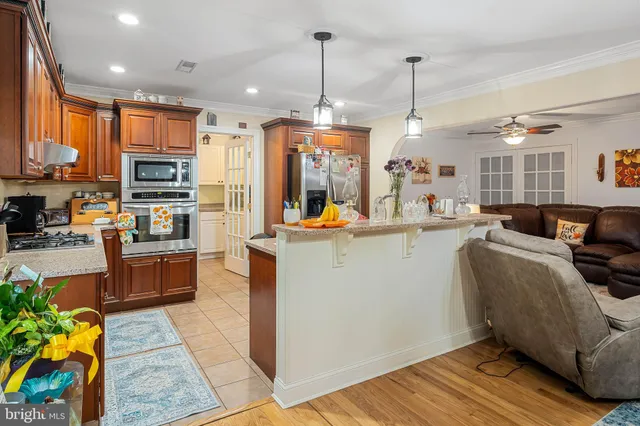 a kitchen view with stainless steel appliances granite countertop a stove and cabinets