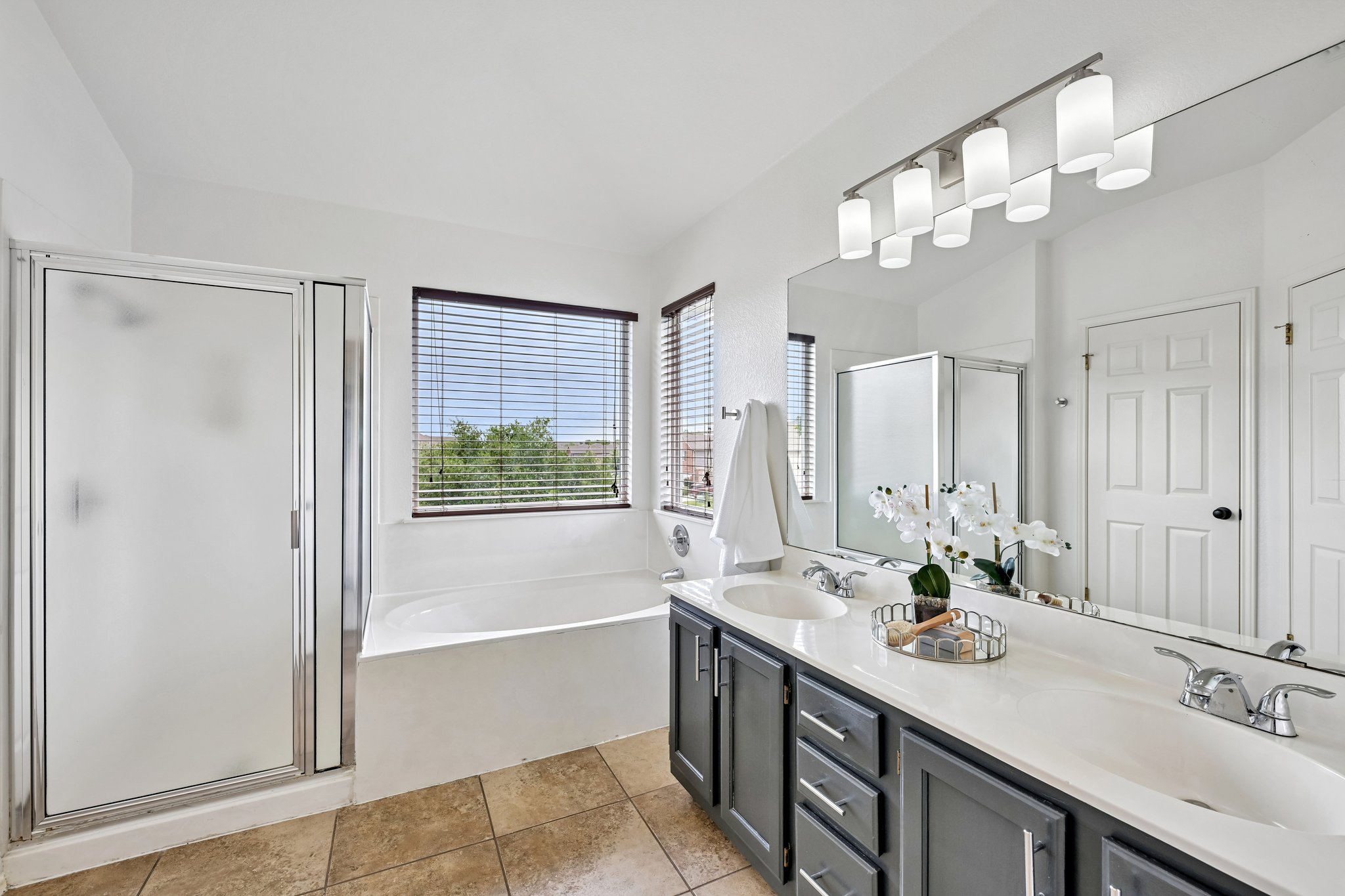 4100 Mocha Trail Austin, TX 78728 - Photo 15 of 33 Indulge in a tranquil bathing experience in this well-lit bathroom featuring a deep soaking tub and a spacious shower.