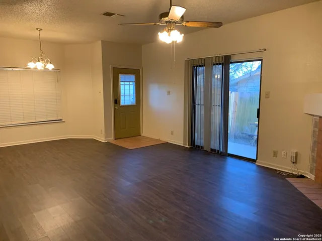 a view of a room with wooden floor and ceiling fan
