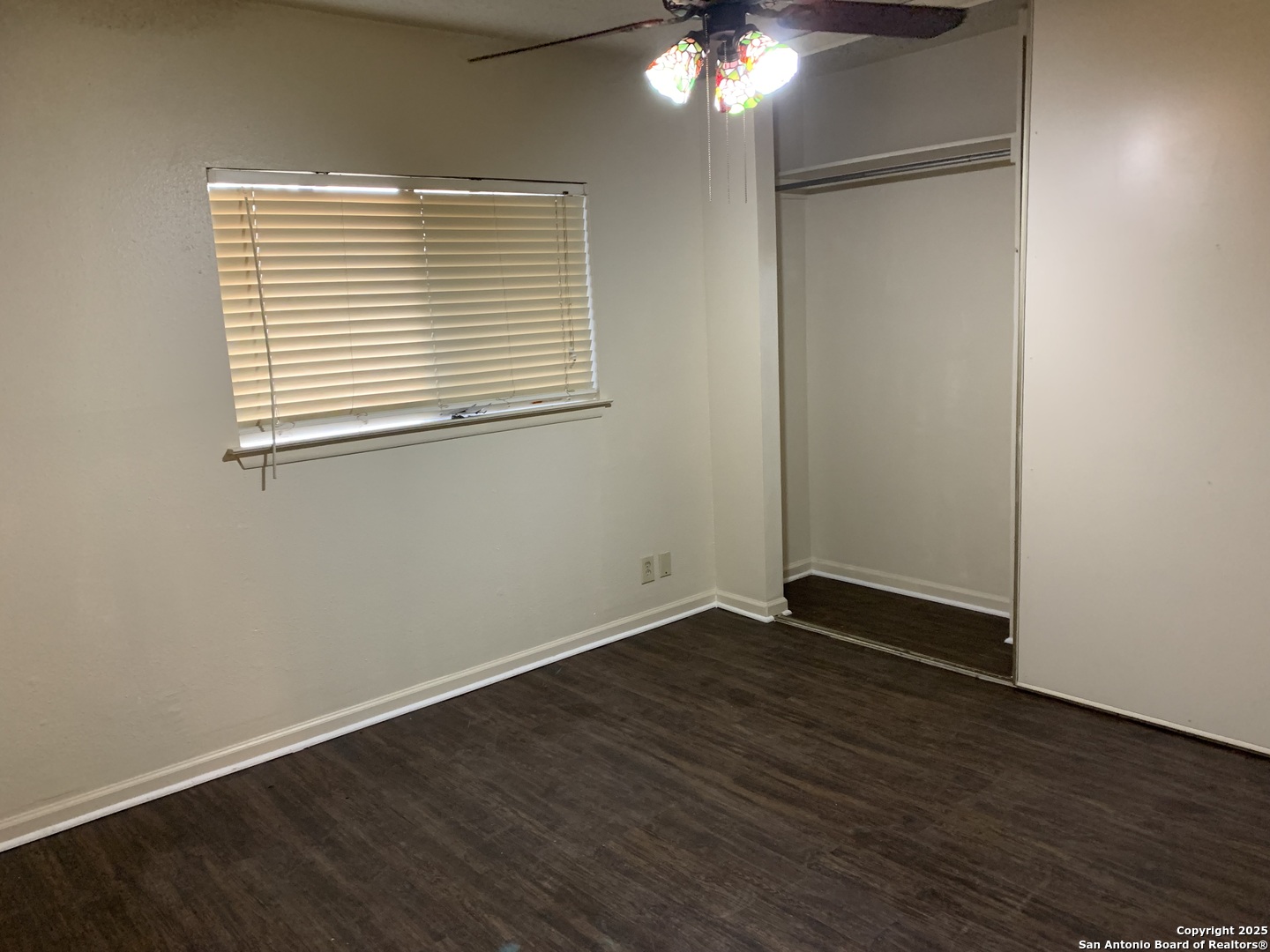 8441 Forest Ridge Drive, Unit 80 San Antonio, TX 78239 - Photo 7 of 10 an empty room with wooden floor and windows