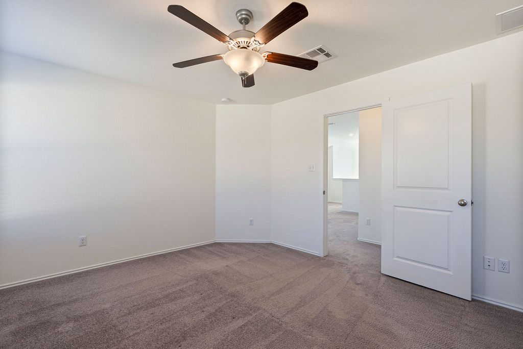 156 Red Buckeye Loop Liberty Hill, TX 78642 - Photo 14 of 27 an empty room with closet and a ceiling fan