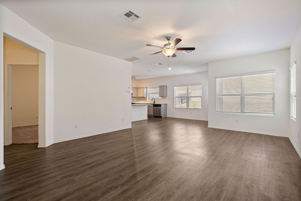 156 Red Buckeye Loop Liberty Hill, TX 78642 - Photo 4 of 27 a view of an empty room with a window and wooden floor