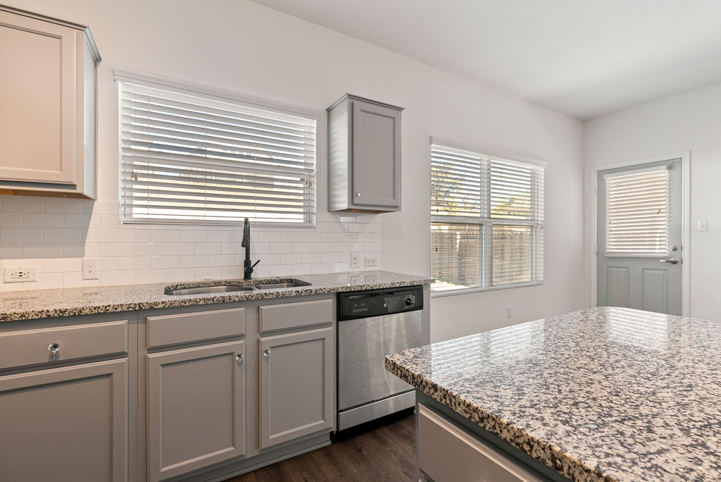 156 Red Buckeye Loop Liberty Hill, TX 78642 - Photo 8 of 27 a kitchen with granite countertop sink cabinets and window