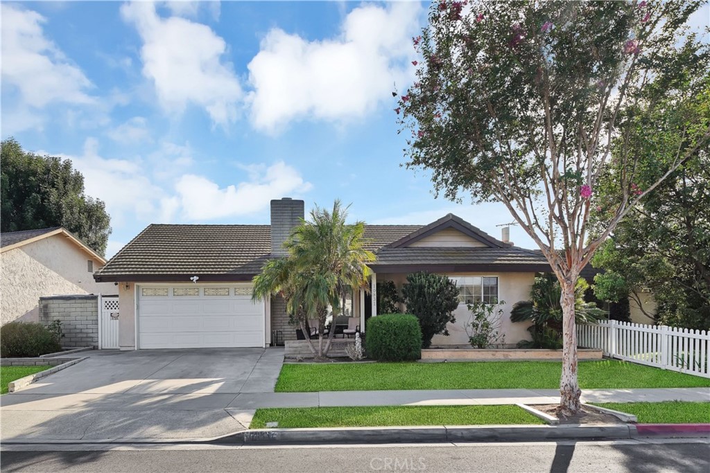 10831 Mitchell Drive Stanton, CA 90680 - Photo 1 of 1 a front view of a house with a garden and trees