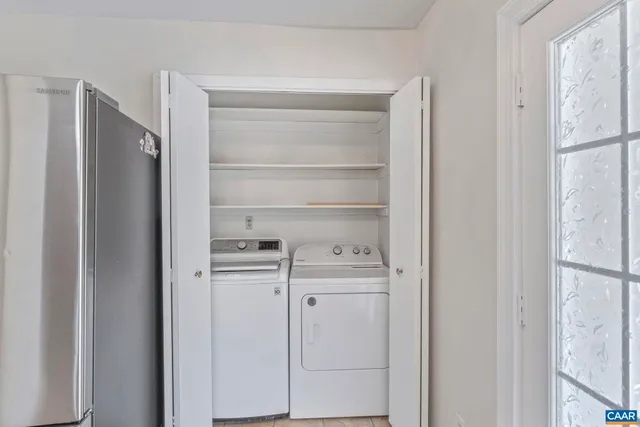 a kitchen with white cabinets and refrigerator
