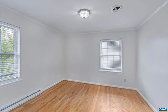an empty room with a window and wooden floor