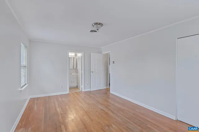 a view of empty room with wooden floor