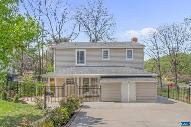 a front view of a house with a garden and trees