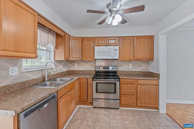 a kitchen with stainless steel appliances granite countertop a sink stove and cabinets