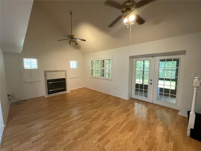 a view of an empty room with a fireplace and a window
