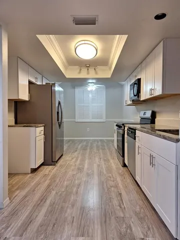 a kitchen with stainless steel appliances a refrigerator and a stove top oven