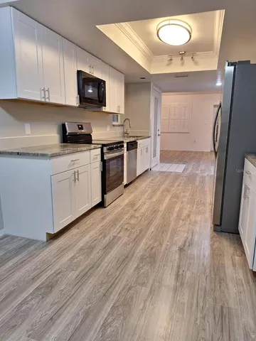 a kitchen with granite countertop a refrigerator stove and sink
