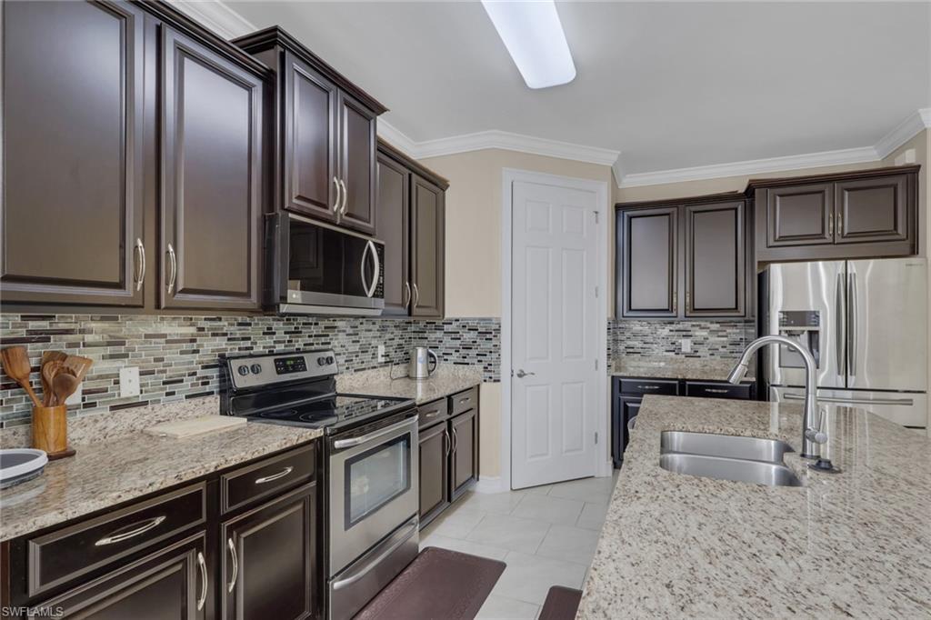 16309 Aberdeen Way Naples, FL 34110 - Photo 7 of 34 a kitchen with stainless steel appliances granite countertop a sink stove and refrigerator