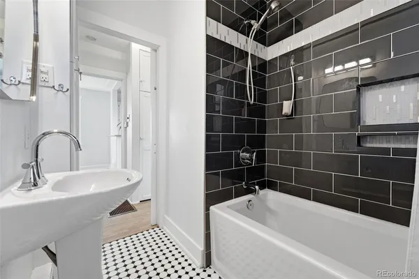 a bathroom with a tub a sink a toilet and shower