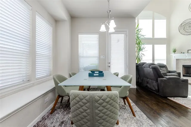 a dining room with furniture a chandelier and wooden floor
