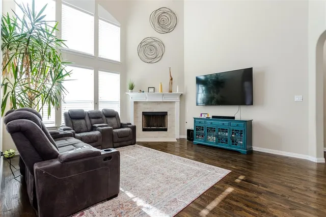 a living room with furniture a flat screen tv and a fireplace