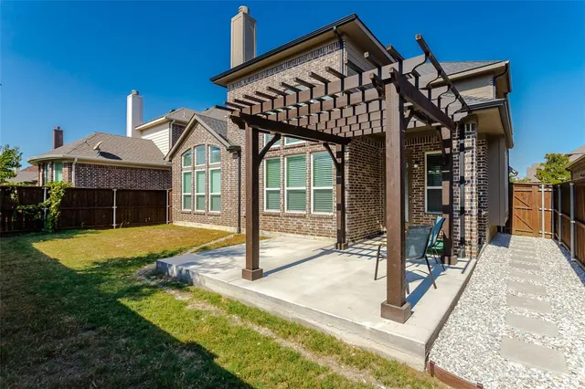a view of a patio with table and chairs with wooden fence