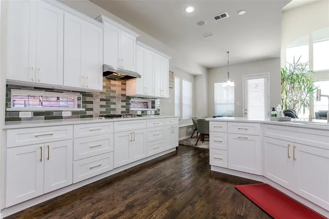 a kitchen with white cabinets and sink