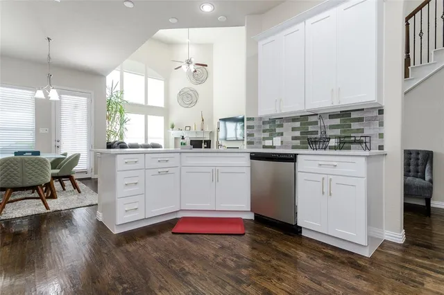 a kitchen with white cabinets and sink
