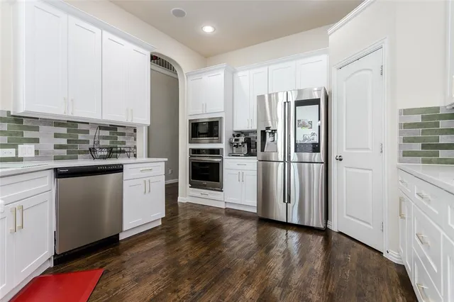 a kitchen with stainless steel appliances a refrigerator sink and microwave