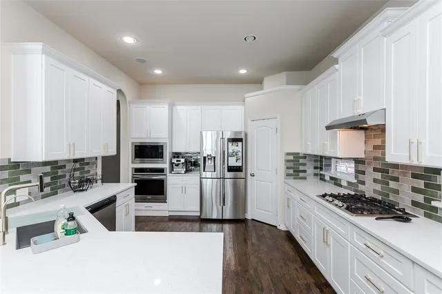a kitchen with stainless steel appliances kitchen island granite countertop a stove and a sink