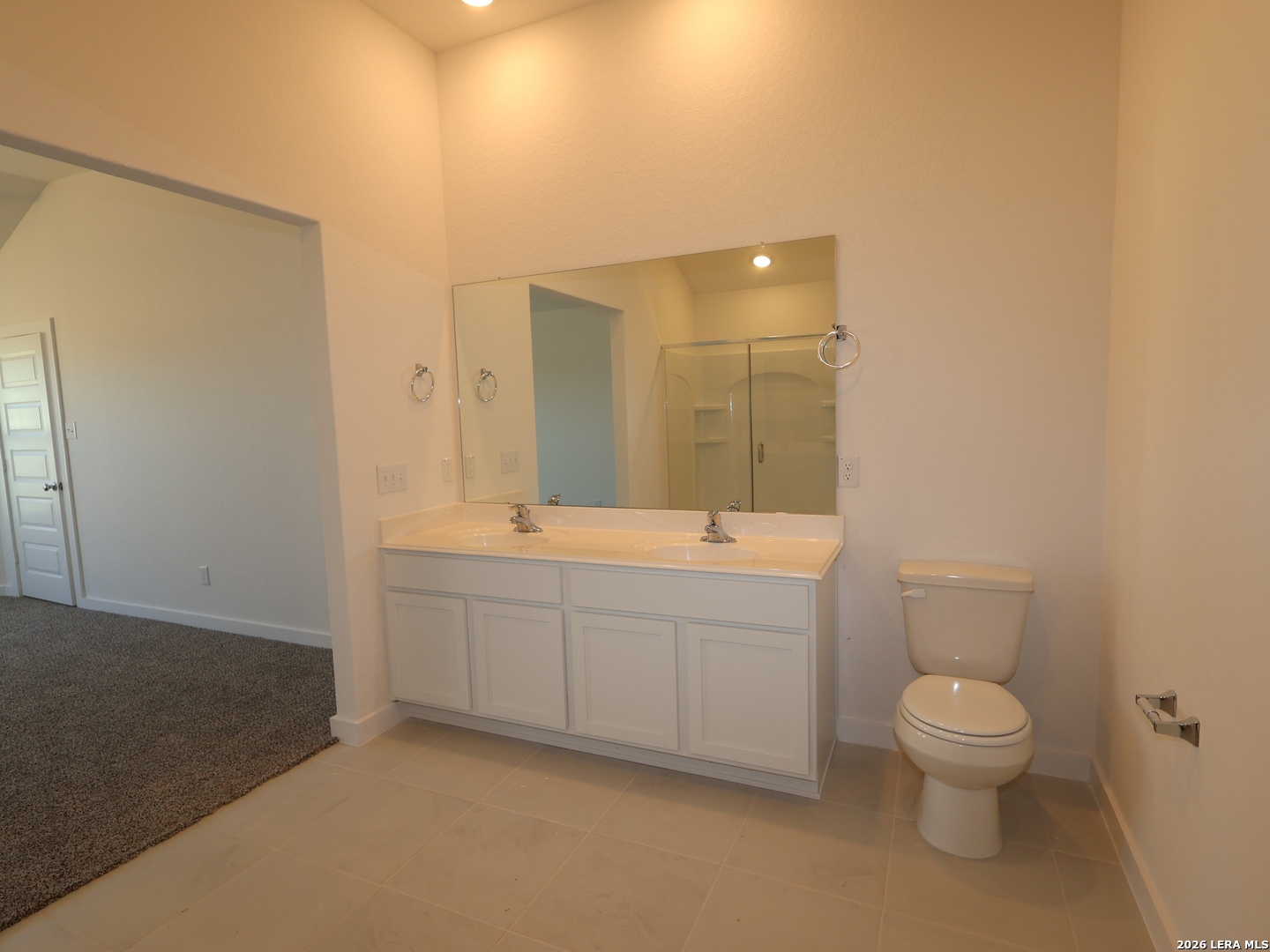 8626 Rucker Pond Trail San Antonio, TX 78252 - Photo 10 of 24 a bathroom with a granite countertop toilet a sink and a mirror