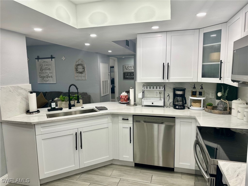 3100 Seasons Way, Unit 108 Estero, FL 33928 - Photo 11 of 40 a kitchen with a sink stove and cabinets