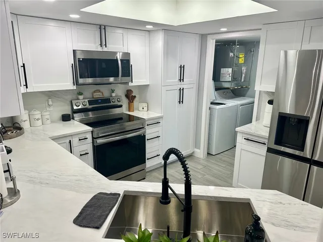 a kitchen with stainless steel appliances a refrigerator stove and sink