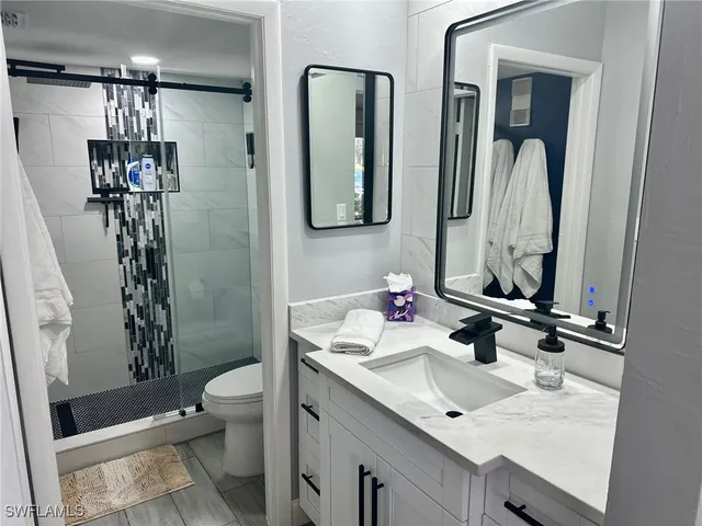 a bathroom with a toilet sink and mirror