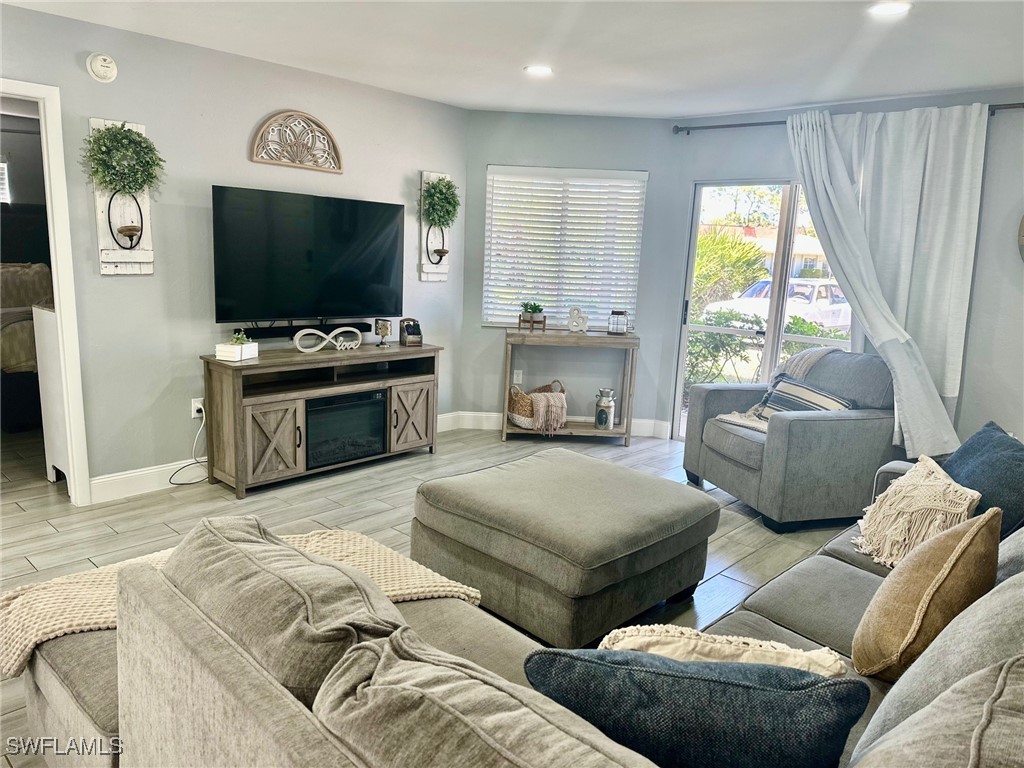 3100 Seasons Way, Unit 108 Estero, FL 33928 - Photo 3 of 40 a living room with furniture and a flat screen tv