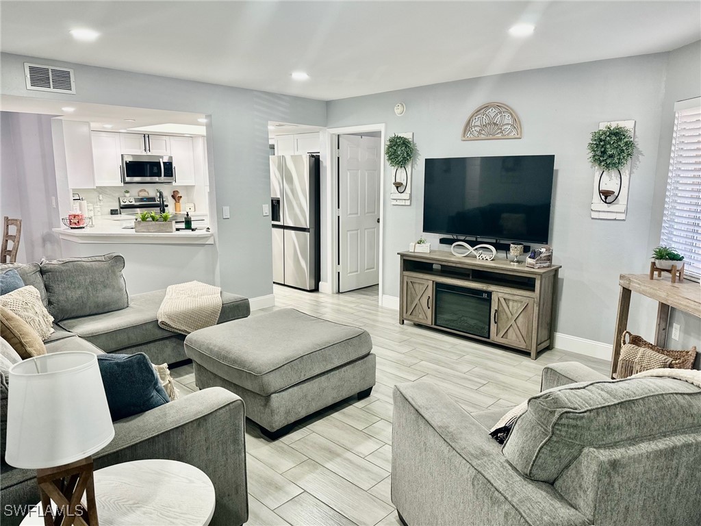 3100 Seasons Way, Unit 108 Estero, FL 33928 - Photo 4 of 40 a living room with furniture and a flat screen tv