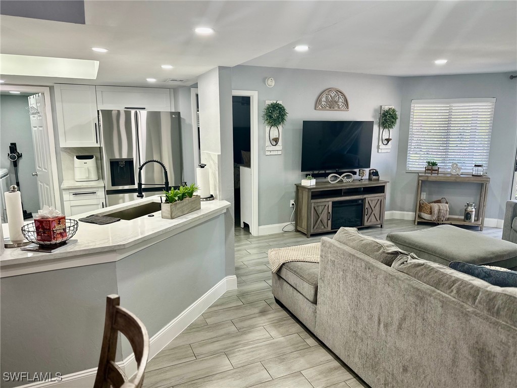 3100 Seasons Way, Unit 108 Estero, FL 33928 - Photo 7 of 40 a living room with stainless steel appliances furniture a flat screen tv and a faucet