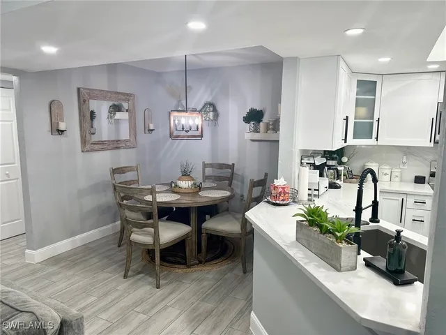 a kitchen with stainless steel appliances a sink a stove a table and chairs