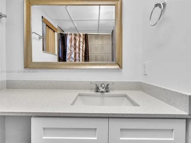 a bathroom with a granite countertop toilet sink and mirror