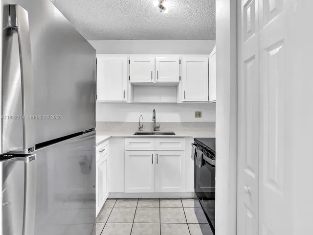 a kitchen with white cabinets and a sink