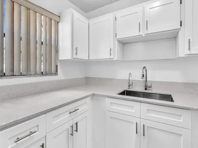 a kitchen with white cabinets and appliances