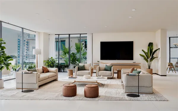 a living room with furniture potted plant and a flat screen tv