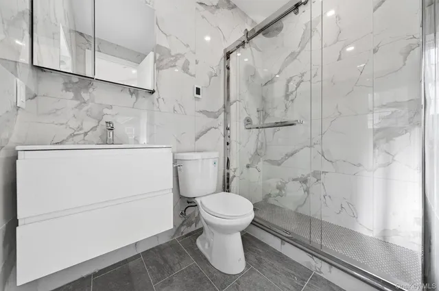 a bathroom with a white toilet and a shower