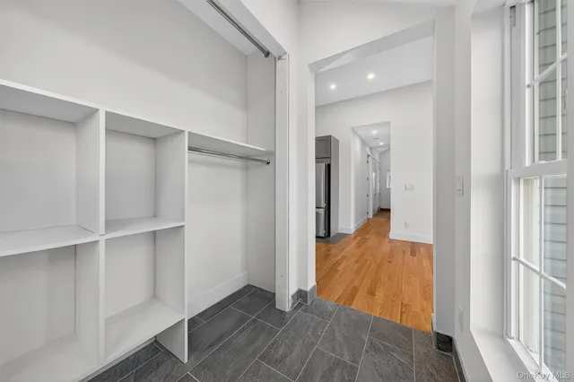 a view of a hallway with wooden floor and closet
