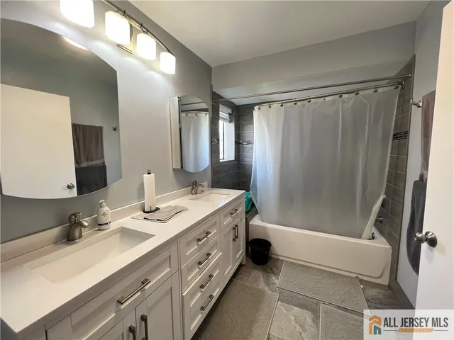 a spacious bathroom with a double vanity sink and a mirror