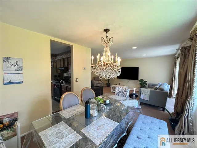 a living room with furniture a chandelier and a flat screen tv