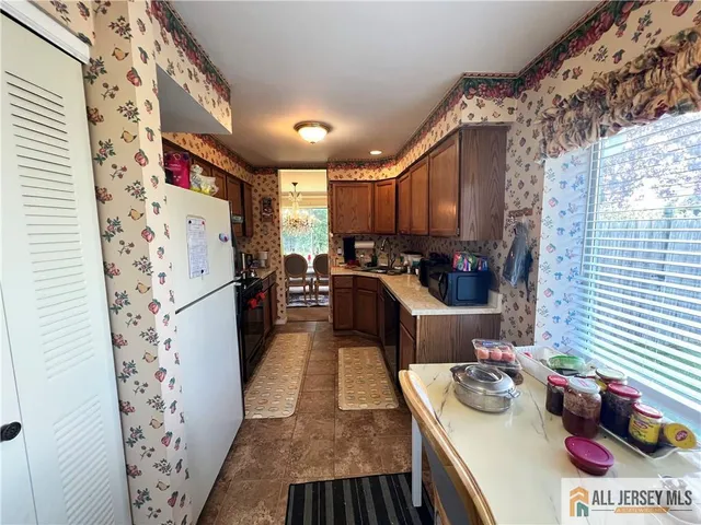 a kitchen with stainless steel appliances kitchen island granite countertop a refrigerator and a stove