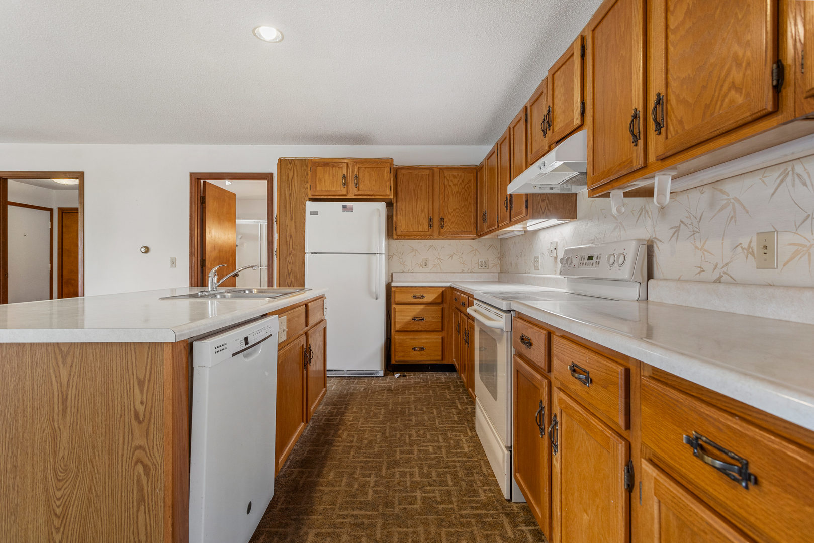 614 South Irving Street Monticello, IL 61856 - Photo 11 of 36 a kitchen with granite countertop a sink and dishwasher a stove top oven with wooden floor