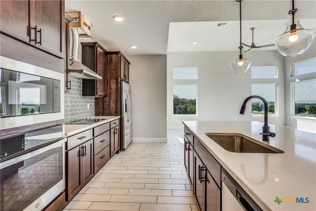 a kitchen with stainless steel appliances granite countertop a sink and oven
