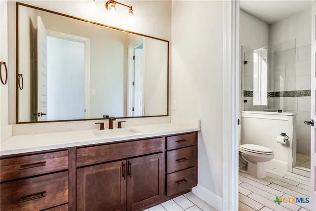 a bathroom with a sink a toilet and a mirror