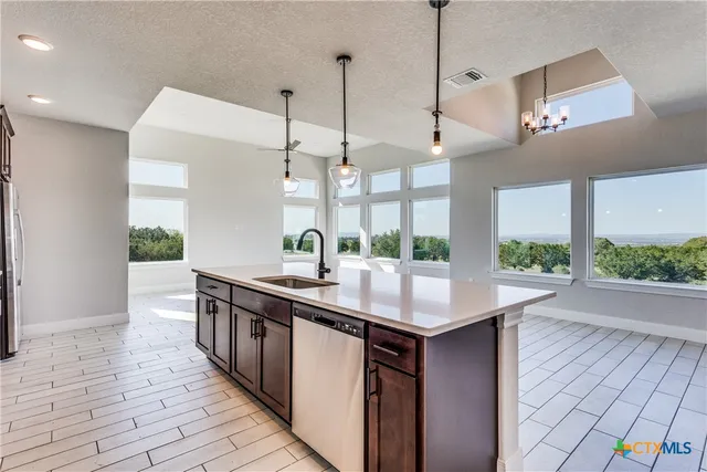 a kitchen with stainless steel appliances granite countertop a sink a oven a counter space and wooden floor