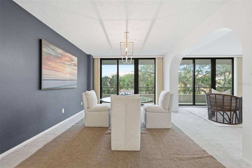 6415 Midnight Pass Road, Unit 211 Sarasota, FL 34242 - Photo 13 of 58 a living room with furniture and large windows