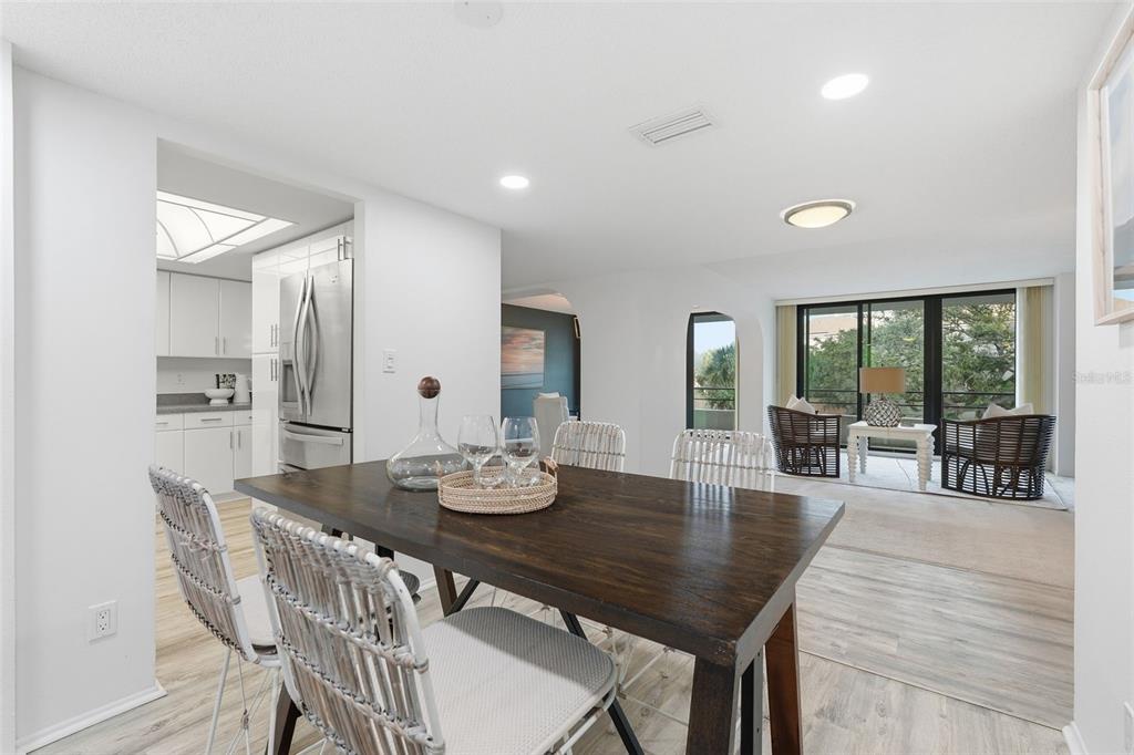 6415 Midnight Pass Road, Unit 211 Sarasota, FL 34242 - Photo 16 of 58 a view of a dining room with furniture and wooden floor