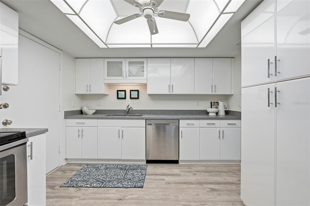 6415 Midnight Pass Road, Unit 211 Sarasota, FL 34242 - Photo 18 of 58 a kitchen with granite countertop a sink cabinets stainless steel appliances and a window