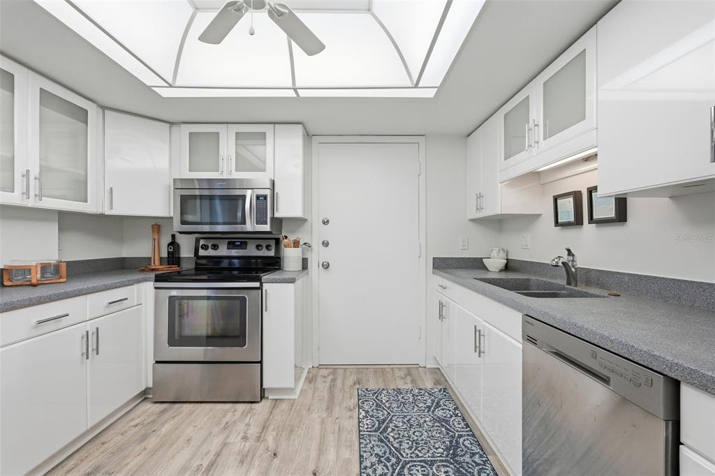 6415 Midnight Pass Road, Unit 211 Sarasota, FL 34242 - Photo 19 of 58 a kitchen with stainless steel appliances granite countertop a stove a sink and a microwave